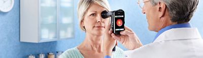 Un médecin utilise l'ophtalmoscope PanOptic™ avec l'accessoire iExaminer pour voir le fond de l'œil de sa patiente sur un smartphone.