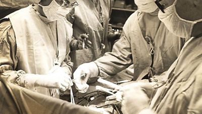 Surgeons work beneath a Trumpf Helion halogen light.