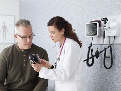 A clinician shows a patient an image from his physical exam.
