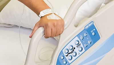 A patient grips the siderail of the Advanta™ 2 Med Surg Bed