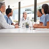 Une équipe de soignants discutent autour d'une longue table.