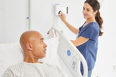 Nurse using Voalte Nurse Call system at patient's bedside