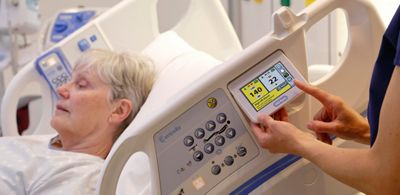 A clinician monitors her patient’s heart and respiratory rates using the HILLROM CENTRELLA Smart+ Bed