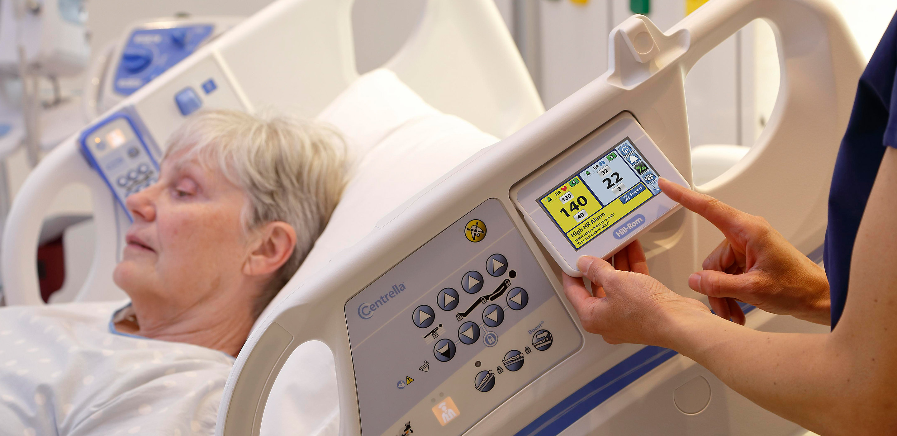 A clinician monitors her patient’s heart and respiratory rates using the HILLROM CENTRELLA Smart+ Bed