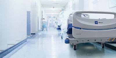 A bed sits empty in the hallway waiting for service