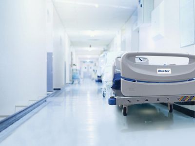 A bed sits empty in the hallway waiting for service