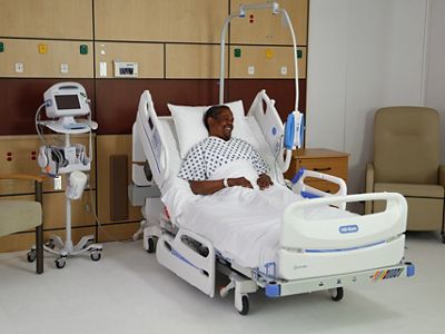 A patient lies in a reclined position in a hospital bed
