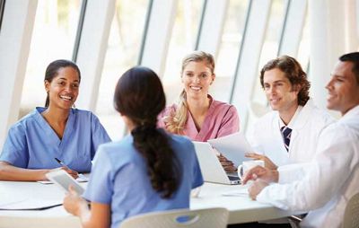 medical professionals sitting at a table having a joyful conversation