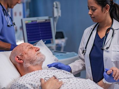 Close-up of nurse using mobile device in hospital hallway