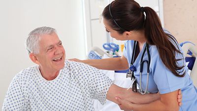 Eine Pflegekraft kümmert sich um einen Patienten