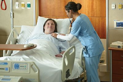 Une infirmière prend soin du patient dans son lit