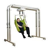 A man sits in a green sling in a FreeSpan UltraTwin lift system from Hillrom