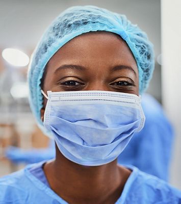Close up view of a smiling nurse wearing PPE