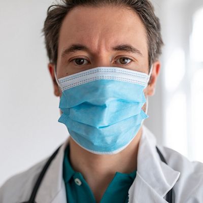 Male clinician confidently looks at the camera while wearing PPE. 