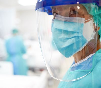 Close up view of a doctor wearing surgical mask and a face shield