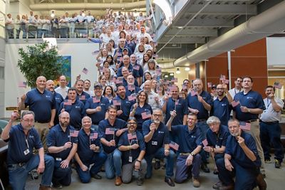 A large group of Hillrom employees poses with American flags to celebrate the launch of the VET employee resource group