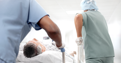 Two care team members transport patient