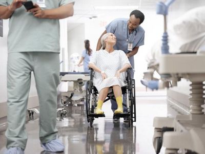 A clinician talks to a patient after transferring her from a bed to a wheelchair