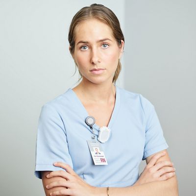 Caregiver has arms confidently crossed wearing the Hillrom Precision Locating staff badge. 