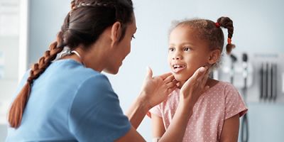 Clinician performs routine exam on child patient