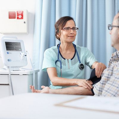 A clinician takes a patient’s blood pressure using a Spot Vital Signs 4400 Device  