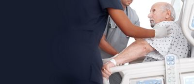 Hospital clinicians help a patient sit up in the Progressa Bed