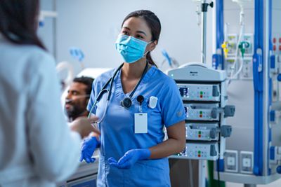 An ICU nurse and physician consult on patient care