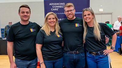A group of Hillrom employees smile in Hillrom Pride Partnership T-shirts