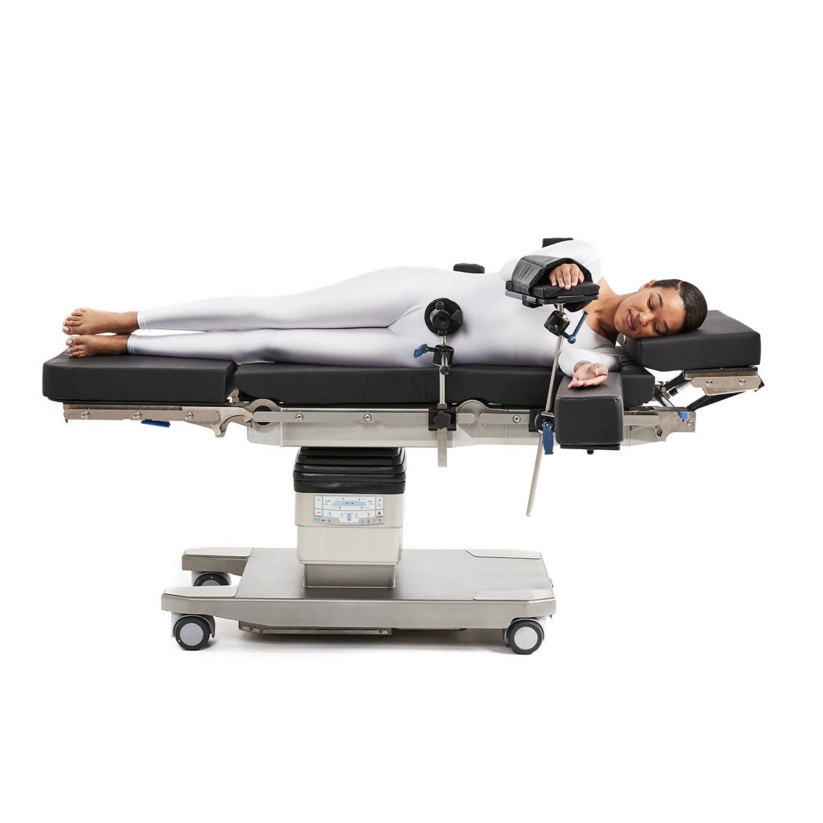 Patient in lateral position on surgical table being supported by siderail mounted braces.