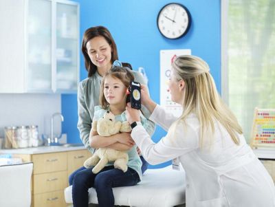 A Welch Allyn Spot Vision Screener shown being used on a smiling child