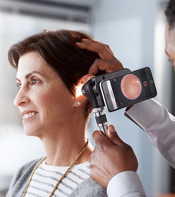 Doctor examining patient’s ear with the MacroView Plus Otoscope.
