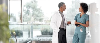 Två läkare samtalar i en sjukhusfoajé