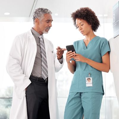 Nurse and clinician looking at a smartphone