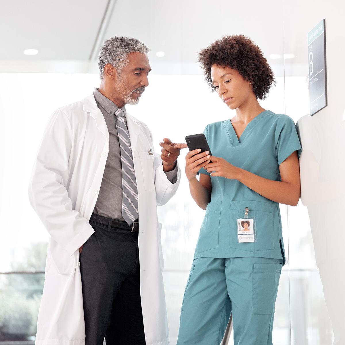 Arzt und Pflegekraft verwenden ein Smartphone