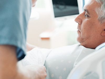 Close-up of nurse and doctor using mobile device in hospital hallway