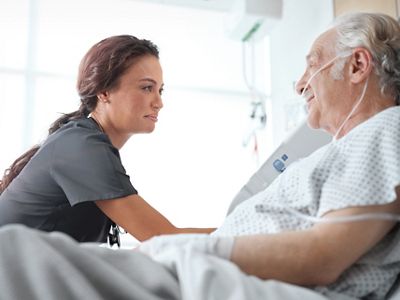 Caregiver assisting a patient in bed