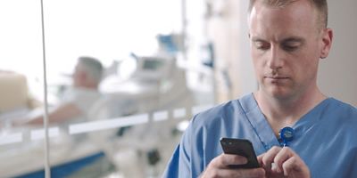 caregiver in foreground using a mobile device