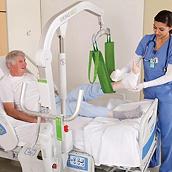 A clinician uses a green MultiStrap Lift Aid to turn a patient in bed
