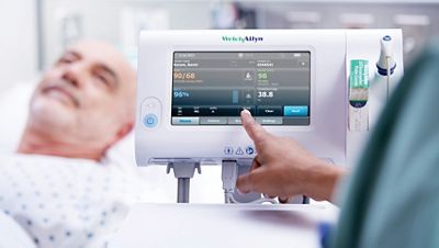 Un clinico attiva lo schermo del monitor Connex Spot che visualizza un punteggio di Early Warning Score pari a 8