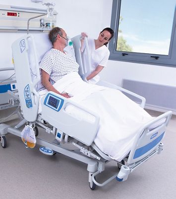 A clinician adjusts the Hillrom 900 Accella Smart Bed for a patient
