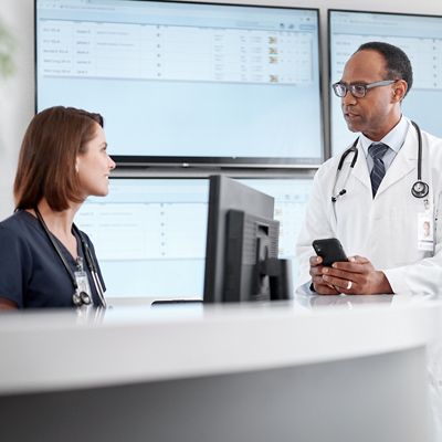 Nurse and physician talking at nurses station.