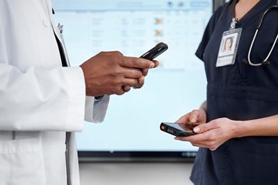 Nurse and physician using iphones to receive and send patient info via Voalte Platform 
