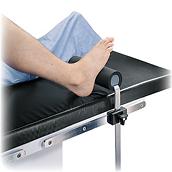 Estabilizador total de joelho, nº O-TKS, instalado na mesa cirúrgica com o pé do paciente apoiado