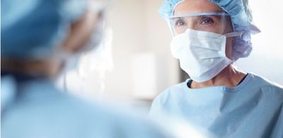Närbild på kvinnlig kirurg i operationssalen
