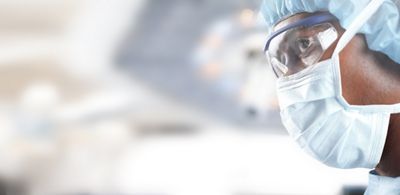 Close-up of a surgical team member during surgery, Hillrom surgical light in the background