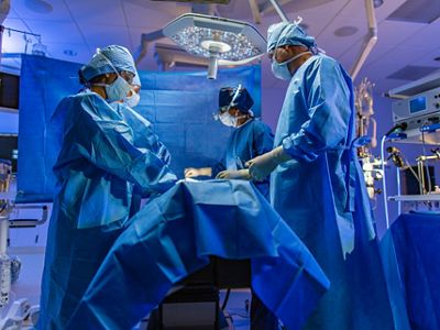 Close-up of doctor using mobile device in hospital hallway