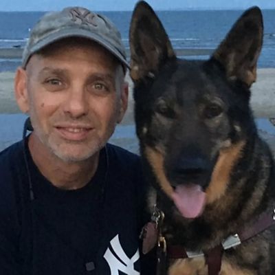 a man smiles with his dog