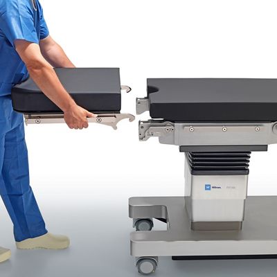 A clinician holds a modular piece of the PST 300 Precision Surgical Table's surface.