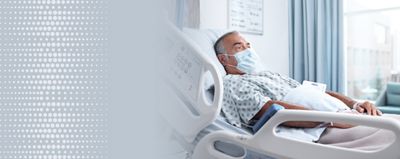 An elderly patient lays in a hospital bed