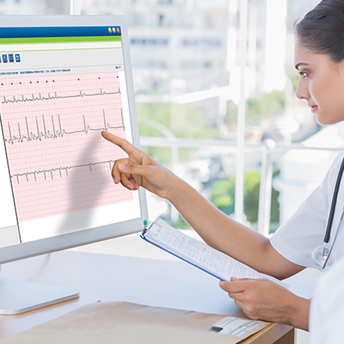 Female clinician pointing to and ECG waveform on a screen